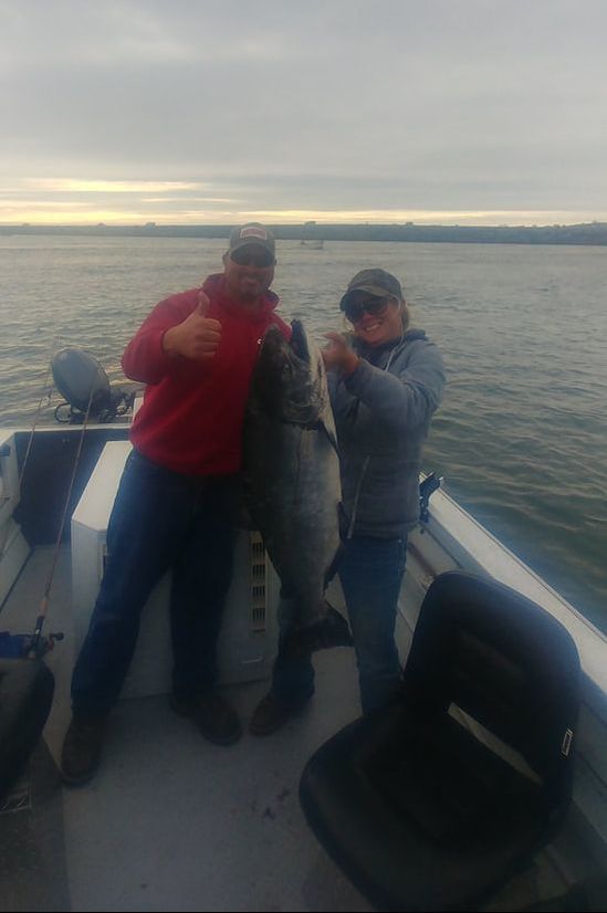 Fishing guide and guest hold up huge king salmon caught on a fishing charter in Southern Oregon.
